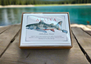 Box with Alaska-themed design featuring a fish illustration on a wooden surface